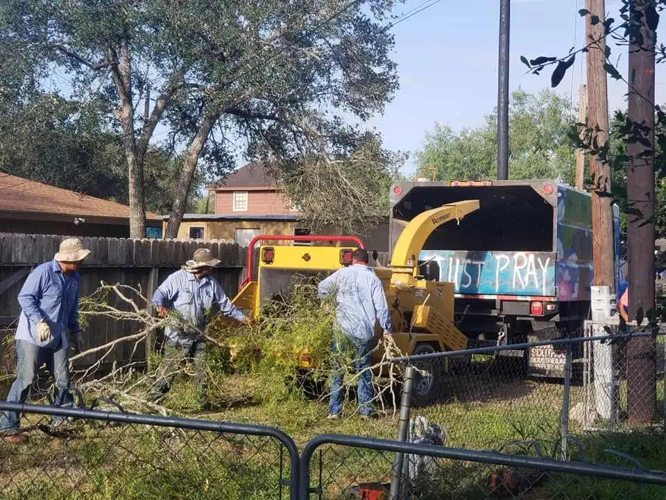 The crew feeding limbs into the chipper